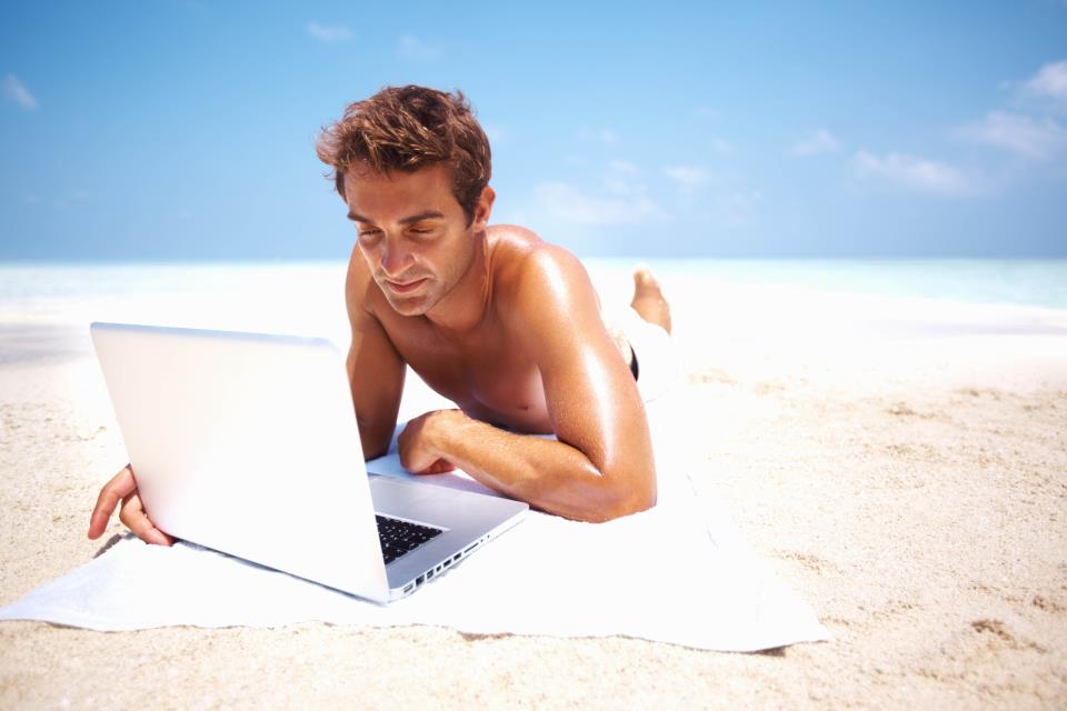 парень с ноутбуком на пляжу